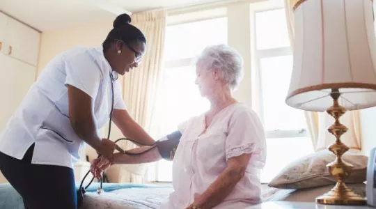 Nurse assisting elderly patient